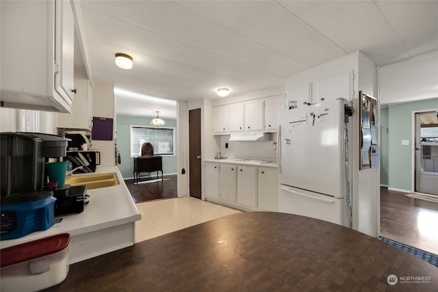 kitchen featuring hardwood / wood-style floors, white cabinetry, and white fridge