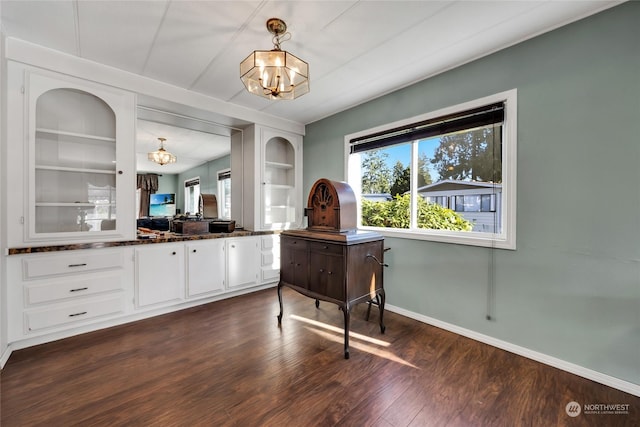 bar with built in features, white cabinets, plenty of natural light, and an inviting chandelier