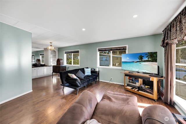 living room with dark wood-type flooring and an inviting chandelier