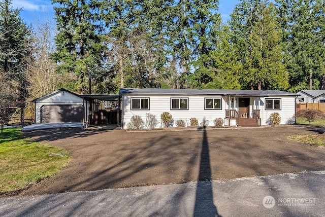 view of front of property featuring an outdoor structure, a carport, and a garage