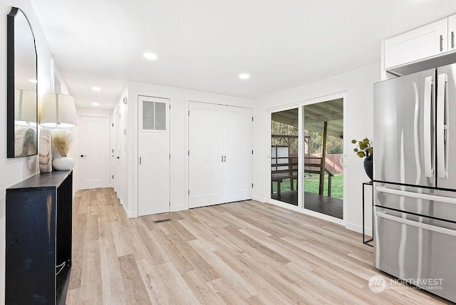 kitchen featuring light wood-type flooring, white cabinetry, and stainless steel refrigerator