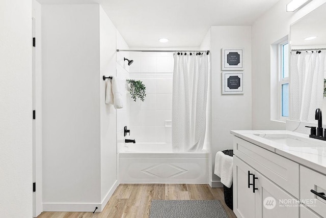 bathroom featuring hardwood / wood-style floors, shower / bath combination with curtain, and vanity