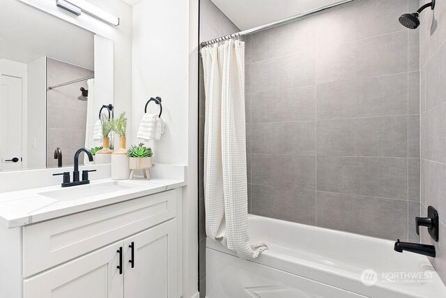 bathroom featuring shower / bath combo with shower curtain and vanity