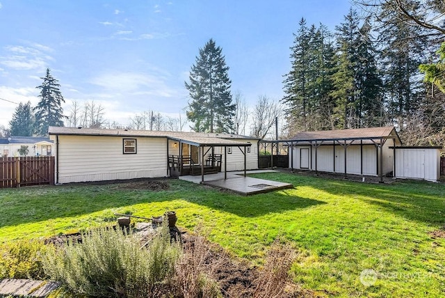 rear view of house with a patio area, a yard, and a storage unit