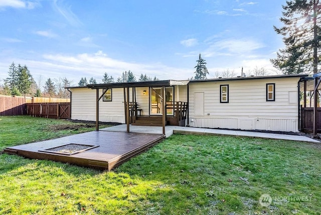 rear view of property with a wooden deck and a yard