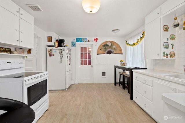 kitchen with white appliances, white cabinetry, sink, backsplash, and light hardwood / wood-style flooring