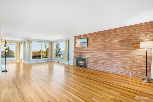 unfurnished living room with a fireplace and light wood-type flooring