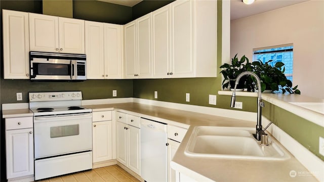 kitchen with white cabinetry, sink, and white appliances