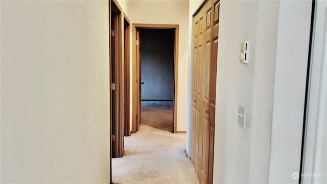 hallway featuring light colored carpet