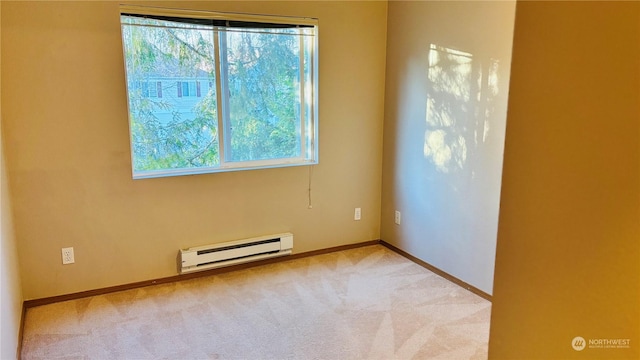 spare room with a baseboard radiator, light colored carpet, and a healthy amount of sunlight