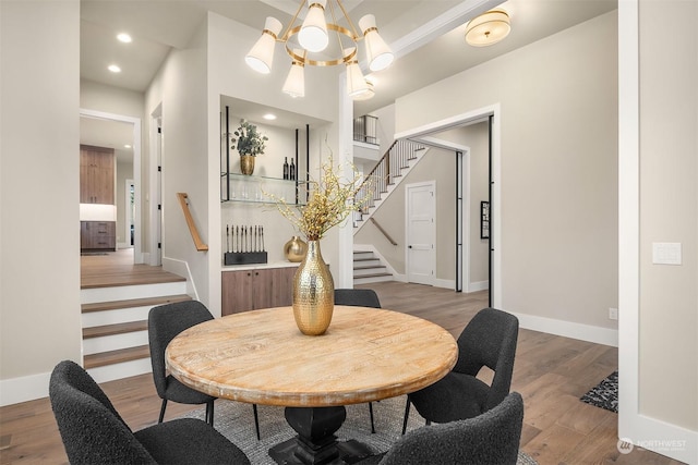 dining room with hardwood / wood-style floors and an inviting chandelier