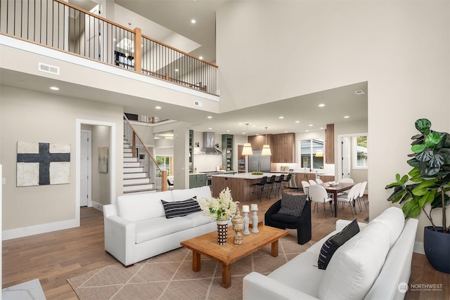 living room with a high ceiling and light wood-type flooring