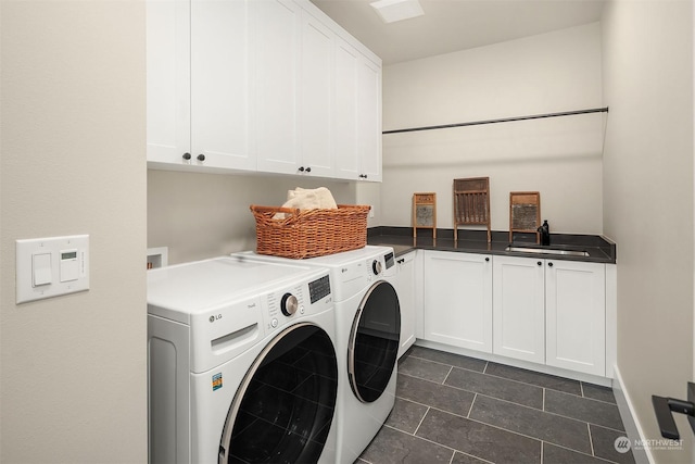 laundry room with sink, cabinets, separate washer and dryer, and dark tile patterned floors