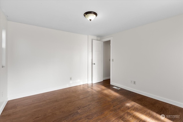 spare room with dark hardwood / wood-style floors