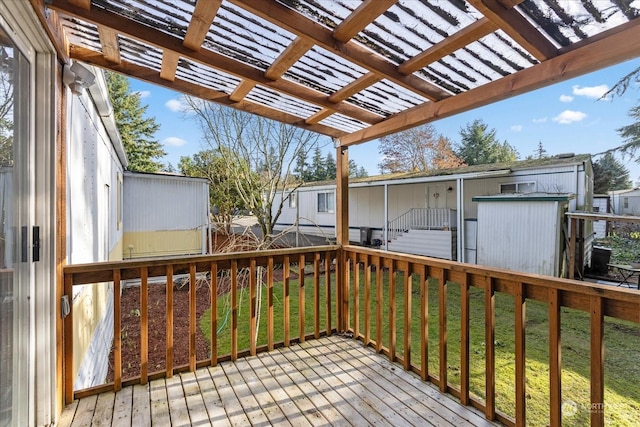 deck with a shed and a lawn