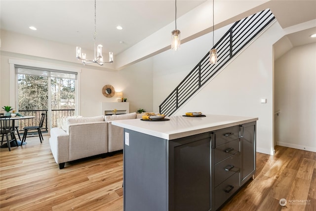 kitchen with an inviting chandelier, light hardwood / wood-style floors, hanging light fixtures, and a kitchen island