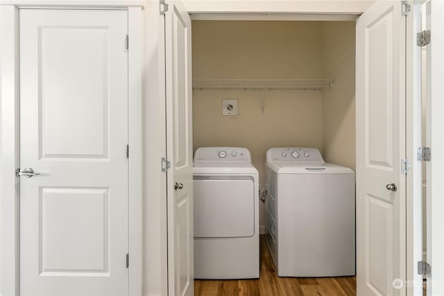 clothes washing area featuring light hardwood / wood-style floors and washing machine and clothes dryer