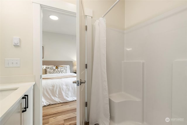 bathroom featuring hardwood / wood-style flooring, vanity, and curtained shower