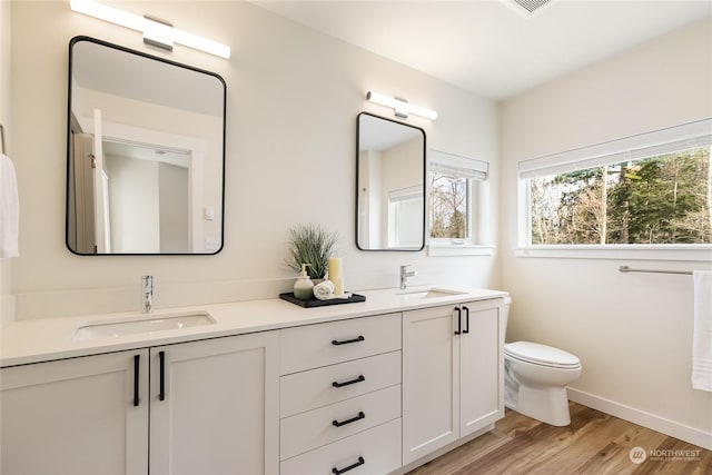 bathroom with vanity, toilet, and hardwood / wood-style floors