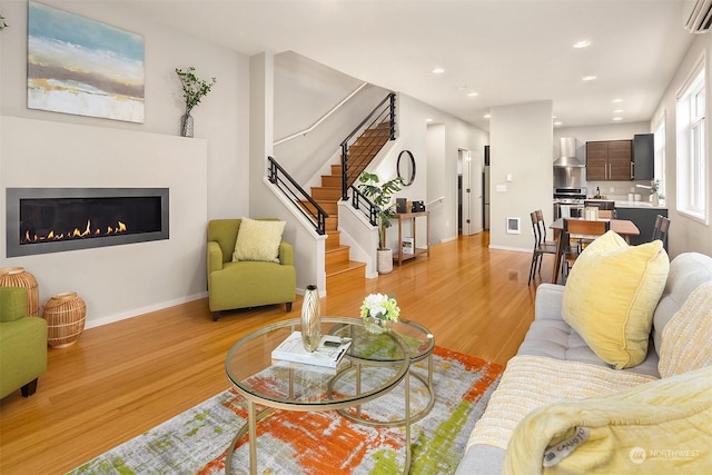 living room with light hardwood / wood-style flooring and an AC wall unit