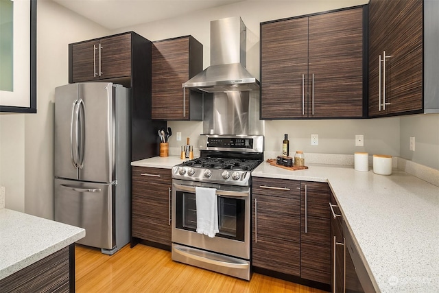 kitchen with dark brown cabinetry, stainless steel appliances, extractor fan, and light hardwood / wood-style flooring