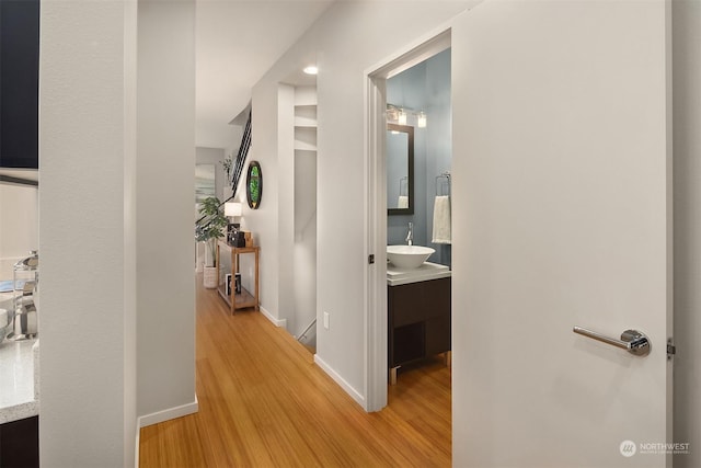 hall with sink and light hardwood / wood-style floors