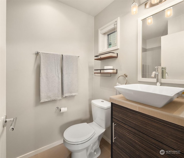 bathroom with tile patterned flooring, vanity, and toilet