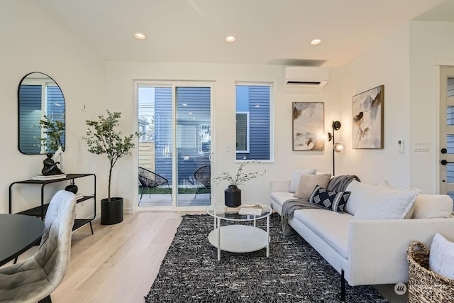 living room featuring a wall mounted air conditioner, light wood-style flooring, and recessed lighting