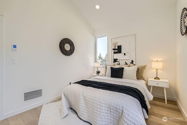 bedroom with light hardwood / wood-style flooring and vaulted ceiling