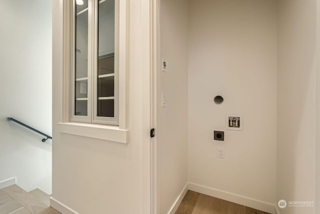 washroom featuring baseboards, hookup for an electric dryer, and wood finished floors