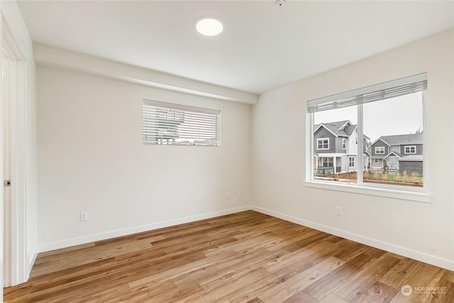 spare room with light hardwood / wood-style flooring and a wealth of natural light