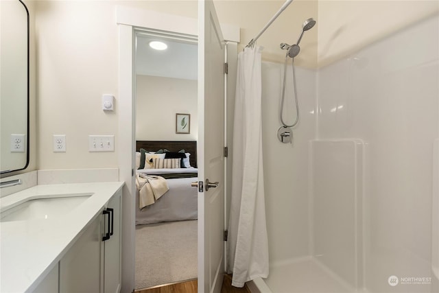 bathroom with hardwood / wood-style flooring, vanity, and curtained shower