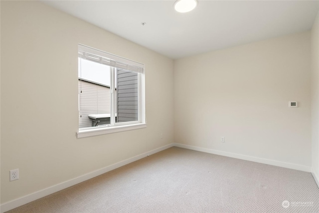 spare room featuring light colored carpet