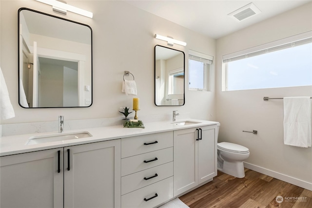 bathroom featuring vanity, hardwood / wood-style flooring, and toilet