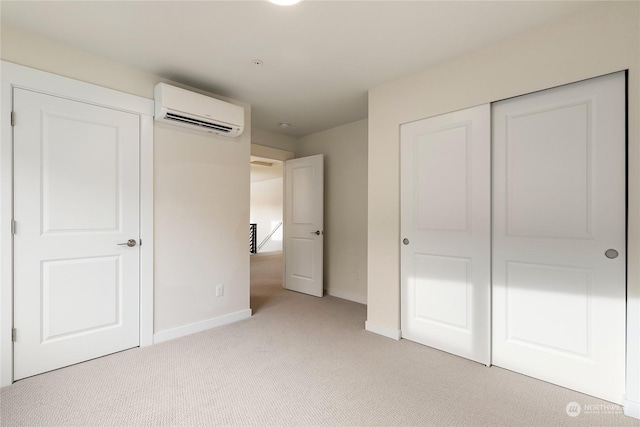 unfurnished bedroom featuring a closet, light carpet, and a wall unit AC