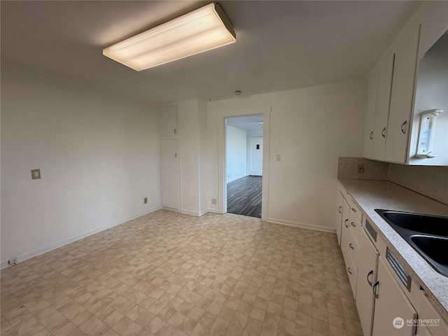 kitchen featuring white cabinetry, sink, and backsplash