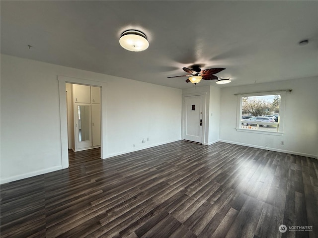 unfurnished living room featuring dark wood-type flooring and ceiling fan