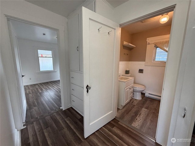 bathroom with vanity, a baseboard heating unit, hardwood / wood-style floors, and toilet