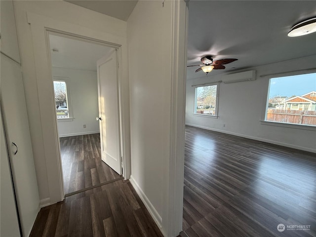 corridor featuring dark wood-type flooring and a wall mounted AC