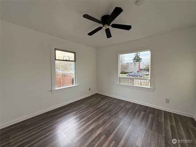 unfurnished room with ceiling fan, dark hardwood / wood-style floors, and a wealth of natural light