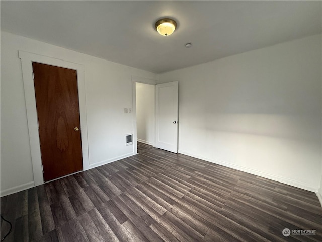 unfurnished bedroom with dark hardwood / wood-style floors and a closet