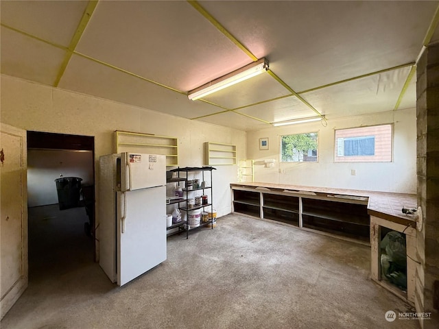 basement with a workshop area and white refrigerator