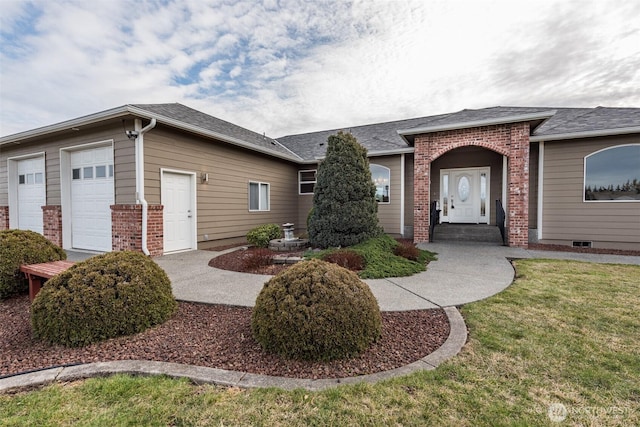 view of front of house with an attached garage, a shingled roof, a front lawn, and brick siding