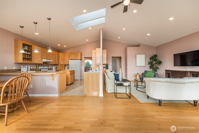 kitchen with light countertops, glass insert cabinets, freestanding refrigerator, open floor plan, and a peninsula