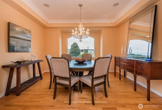 dining room featuring light wood-style floors, a notable chandelier, and baseboards