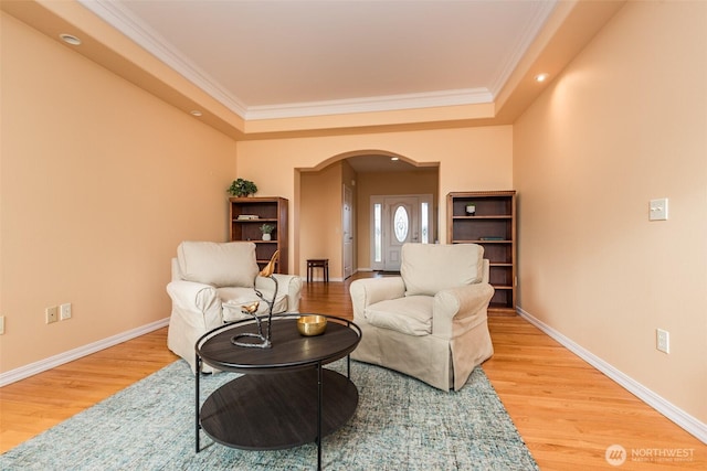 sitting room with arched walkways, wood finished floors, and baseboards