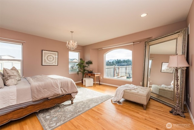 bedroom featuring an inviting chandelier, baseboards, wood finished floors, and recessed lighting