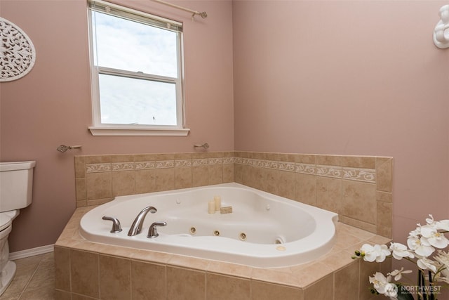 full bath featuring a whirlpool tub, toilet, and tile patterned floors