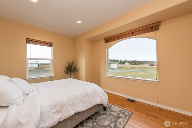 bedroom featuring recessed lighting, wood finished floors, visible vents, and baseboards