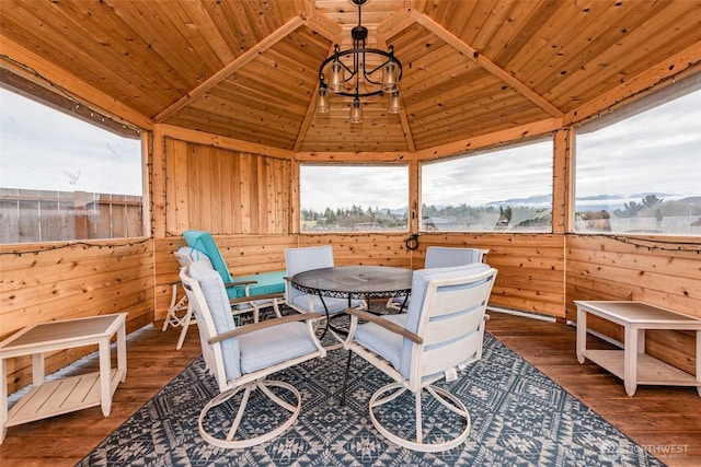 sunroom / solarium with lofted ceiling, wooden ceiling, and an inviting chandelier